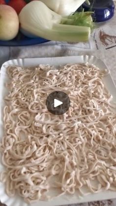 there is noodle noodles on the table with vegetables in the background and a video player