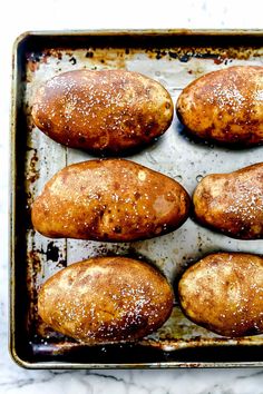 baked potatoes on a baking sheet covered in powdered sugar