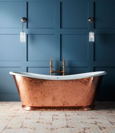 an old fashioned bathtub in a bathroom with blue walls