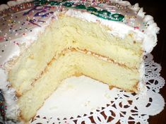 a cake with white frosting and sprinkles is on a doily