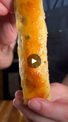 a person holding up a piece of food in their hand with the video below it