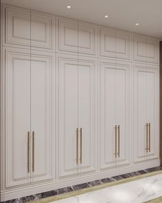 an empty room with white cabinets and marble flooring