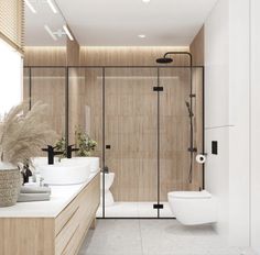 a bathroom with two sinks and a toilet in the center, along with a walk in shower