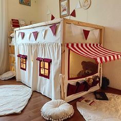 a child's bed with a red and white tent on the floor next to it