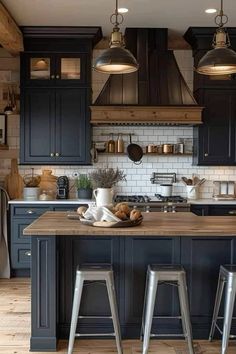 a kitchen with black cabinets and wooden floors