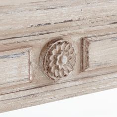 an old white painted dresser with carvings on the front and side panels, including a door handle