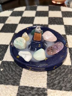 a blue plate topped with rocks on top of a checkered table