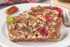 two pieces of fruit and nut bars on a white plate with a fork next to it