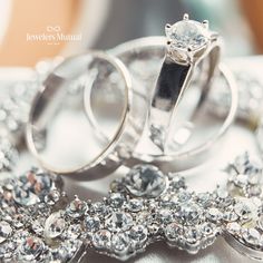 two wedding rings sitting next to each other on top of a white cloth covered table