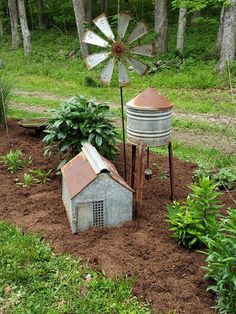 an old farm house is in the middle of some dirt and grass with a windmill on top