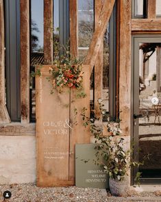 a wooden sign sitting on the side of a building