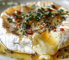 a close up of a plate of food with cheese and herbs on it's surface