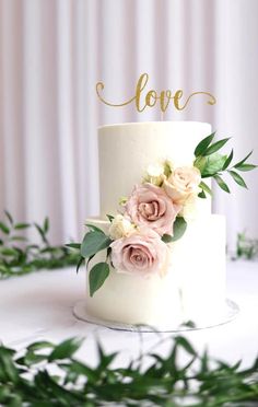 a white wedding cake with pink flowers and greenery on top that says alwayss