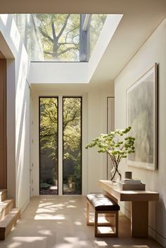 a hallway with a skylight and two benches next to the entryway leading to another room