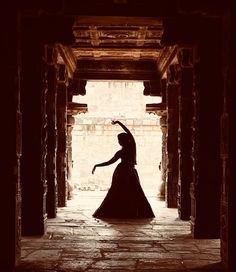 the silhouette of a woman in a long black dress is shown through an open doorway