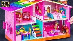 a pink doll house with furniture and accessories