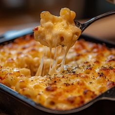 a close up of a fork with some food in it on a pan and one is being lifted from the casserole