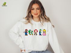 "Super Mario Characters Sweatshirt, Toad Yoshi Sweater, Video Game Hoodie, Kids Birthday Gift, Retro Cartoon Sweatshirt, Princess Sweatshirt Hello there! Welcome to TeesTurtle! We are thrilled to have you here and consider you not just a customer but a friend. Our primary goal is to bring happiness to your life through our unique designs. If you have any questions or would like to request a custom design, please don't hesitate to reach out to us. We are dedicated to ensuring your satisfaction and will do our best to exceed your expectations. HOW TO ORDER YOUR SHIRT? Take a moment to review all the photos of the product. Select your desired T-Shirt Size and T-Shirt Color from the dropdown menus. Choose the quantity you desire. Click the ADD TO CART button. You can continue shopping or proce White Casual Sweatshirt For Birthday, Casual White Sweatshirt For Birthday, White Long Sleeve Hoodie For Birthday, Princess Sweatshirt, Super Mario Characters, Gaming Hoodie, Diy Sweatshirt, Retro Cartoon, Cartoon Sweatshirts