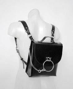 NOIR medium black leather backpack - handmade fashion accessory by MadElephant. It's made of genuine tight black leather, and metal hardware with premium quality carabiners. - Harness backpack - designed with leather straps and d-rings; - Ring backpack - designed with big ring and detachable chain; - Crystal backpack - designed with holographic faux-leather crystal details and natural moon stones. There are two pockets (one inside and one on the back). There is a magnet clasp under the flap (with buckle closure imitation). Top handle. Each medium black leather backpack has adjustable shoulder straps with metal details. Size: 26 x 22 x 8 cm (10.2 x 8.6 x 3.2 in). Noir mini collection - classic style handbags and backpacks with original design. Luxury Designer Leather Backpack With Detachable Strap, Luxury Designer Satchel Shaped As Standard Backpack, Cheap Shoulder Bag With Detachable Strap And Backpack Shape, Cheap Gothic Shoulder Bag, Luxury Edgy Bags With Metal Hardware, Luxury Edgy Bag With Metal Hardware, Cheap Gothic Bags For Halloween, Cheap Alternative Black Bags, Affordable Gothic Halloween Bags