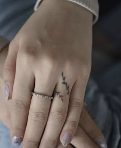 a woman's hand with a small tattoo on it