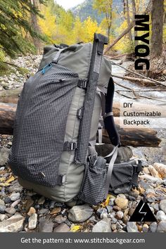 the back pack is sitting on some rocks near a stream with trees in the background