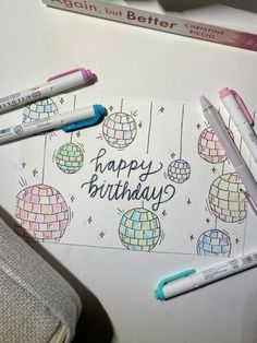 some pens are laying on top of a birthday card