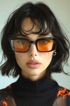 a woman with dark hair and orange tinted glasses