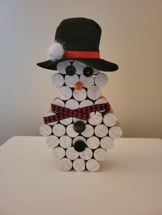 a snowman made out of wine corks with a hat and scarf on it