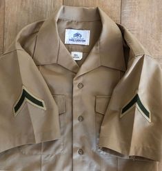 "This is a Vintage Marine Uniform Shirt circa 1980's Men's Size Length: 29\" Chest: 42\" All buttons are included and no obvious holes or stains. 75% Polyester 25% Wool Very Good condition! Please feel free to contact me with any questions. I am happy to help :)" Khaki Short Sleeve Button-up Shirt, Retro Khaki Button-up Shirt, Khaki Collared Shirt With Snap Buttons, Military Style Collared Shirt With Snap Buttons, Military Style Collared Top With Snap Buttons, Vintage Khaki Tops With Snap Buttons, Military Style Collared Top With Button Closure, Vintage Military Uniforms, Marines Uniform