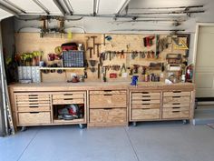 a garage with many drawers and tools on the wall, including workbench cabinets