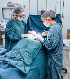 two doctors performing surgery on a patient in an operating room