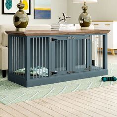 a dog kennel is sitting on the floor in front of a couch and table