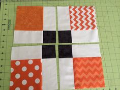 an orange and white patchwork piece on a cutting board