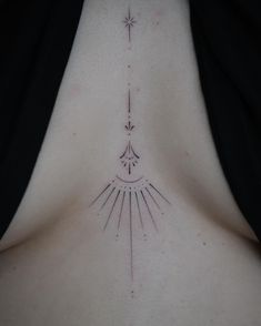 the back of a woman's chest with an arrow and stars tattoo on it