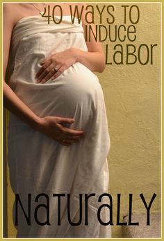 a pregnant woman wearing a white dress standing in front of a yellow wall with her hand on her belly