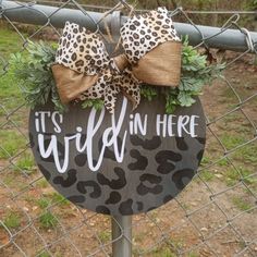 a sign that says it's wild in here with a leopard print bow on top