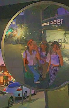 the reflection of three girls in a mirror