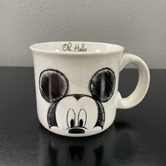 a mickey mouse coffee mug with the name or hula on it's face