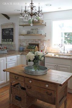 a kitchen with white cabinets and an island in front of the stove top is filled with flowers