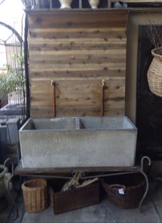 an old wash basin is sitting on the floor next to some baskets and other items