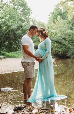 a pregnant couple is standing in the water