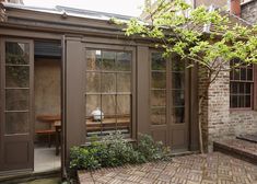 a brick patio with doors and windows on the side