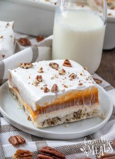 a piece of dessert sitting on top of a white plate next to a glass of milk