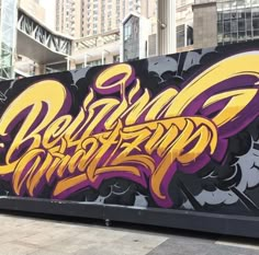 graffiti on the side of a building with buildings in the background