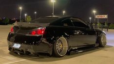 a black sports car parked in a parking lot at night