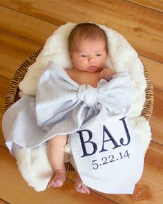 a baby in a basket with a big bow