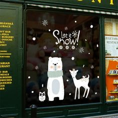 a store front window with an image of a polar bear and two deer