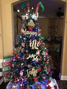 a decorated christmas tree in the middle of a living room with presents on it and decorations