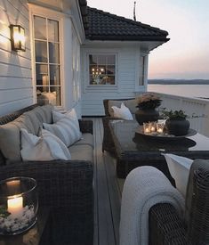 a porch with wicker furniture and candles on it