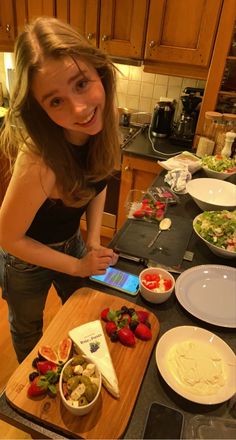 a woman standing in front of a counter with food on it